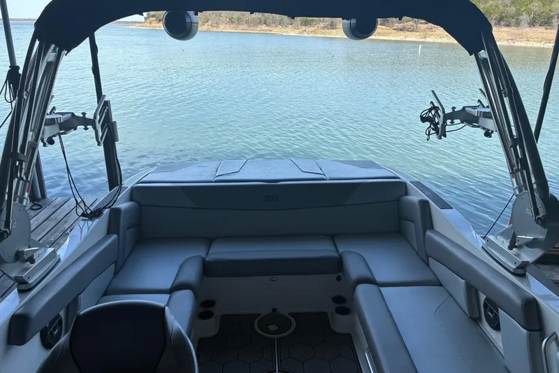 Slide: The Image of 2018 MasterCraft NXT22 boat interior with seating, overlooking a serene lake. - 6
