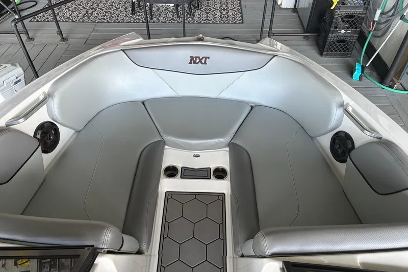 Slide: The Image of 2018 MasterCraft NXT22 boat interior with gray seating and cup holders. - 7