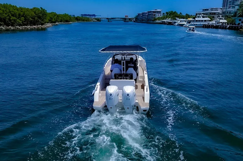 Slide: The Image of Windy SR28 CC 2024 on a waterway with twin outboard engines and a sunshade. - 2