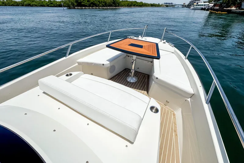 Slide: The Image of The image shows the foredeck of a 2024 Windy SR28 CC boat with a wooden table. - 13