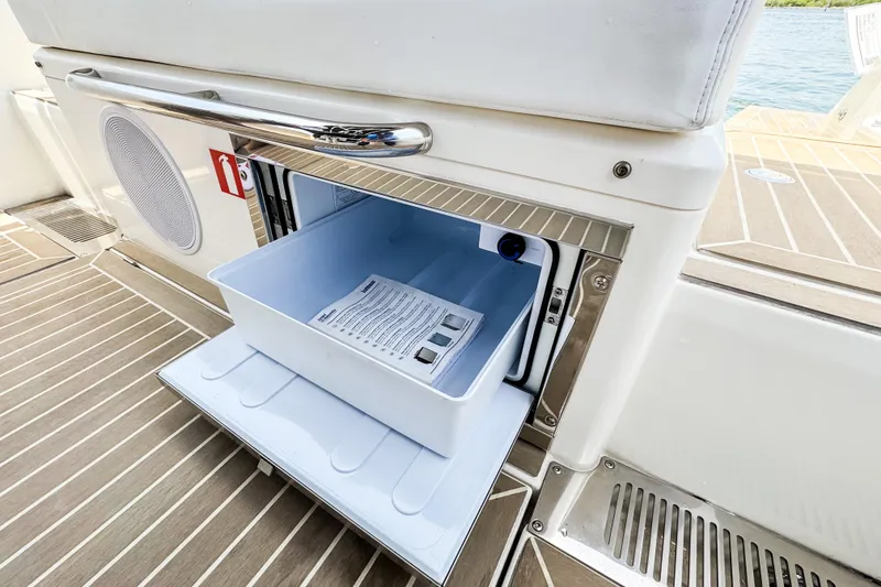 Slide: The Image of An open cooler compartment on a boat with wooden flooring and a white seat. - 18