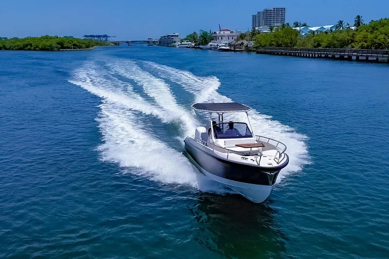 Slide: The Image of A 2024 Windy SR28 CC cruising on calm waters with a cityscape in the background. - 1