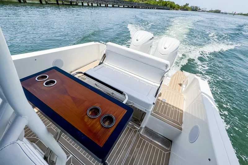 Slide: The Image of The image shows the stern of a 2024 Windy SR28 CC boat with a sleek wooden table and two engines. - 17