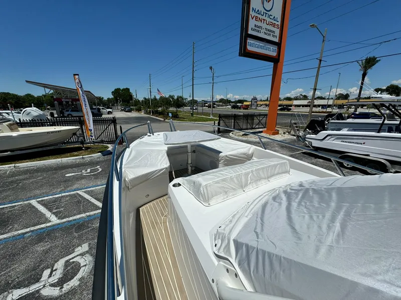 Slide: The Image of 2024 Windy SR28 CC boat on display at a dealership under clear blue skies. - 22