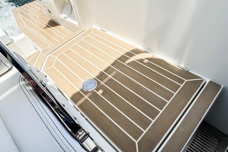 Slide: The Image of The image shows the deck of a 2024 Windy SR28 CC boat with a wood-like finish. - 20