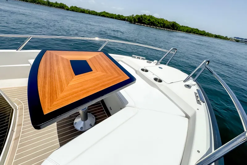 Slide: The Image of A sleek table on a modern boat overlooking calm waters and green shores. - 14