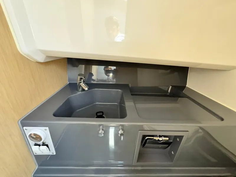 Slide: The Image of Compact kitchen area in the 2024 Windy SR28 CC boat with sink and faucet. - 17