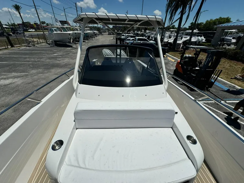 Slide: The Image of 2024 Windy SR28 CC boat with white seating and windshield in a marina. - 8