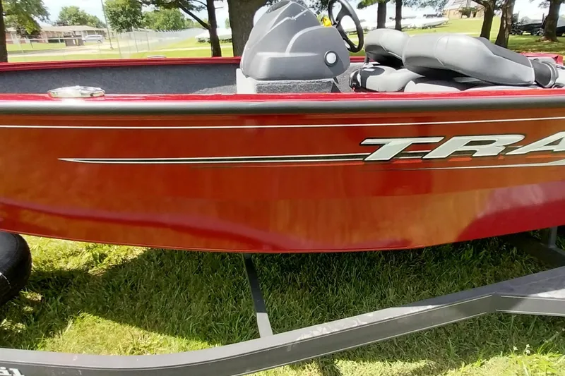 Slide: The Image of 2025 Tracker Super Guide V-16 SC boat on grass, showcasing sleek red design. - 14