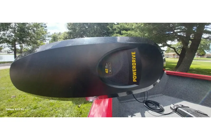 Slide: The Image of PowerDrive motor on 2025 Tracker Super Guide V-16 SC boat, outdoors in a grassy area. - 16