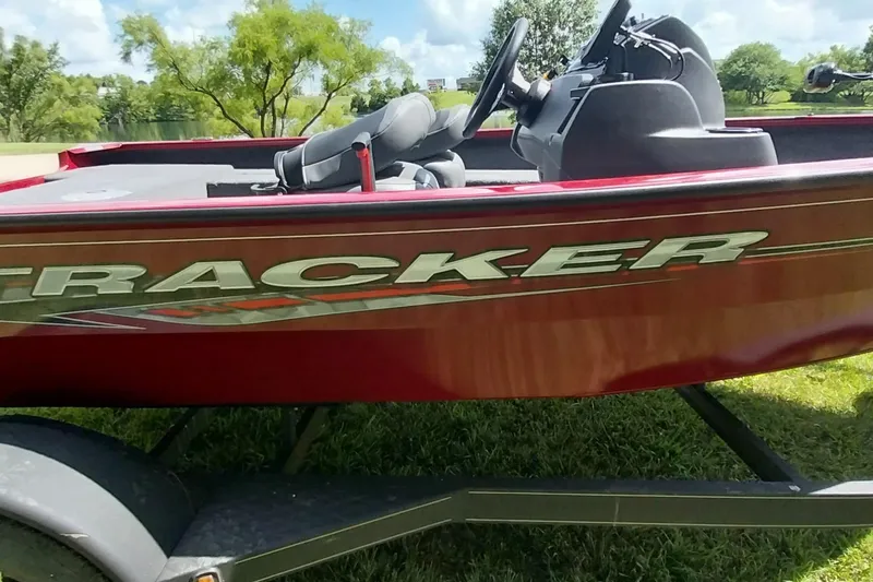 Slide: The Image of 2025 Tracker Super Guide V-16 SC boat on grassy area, side view. - 2