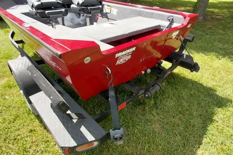 Slide: The Image of Red 2025 Tracker Super Guide V-16 SC boat on trailer, parked on grass. - 20