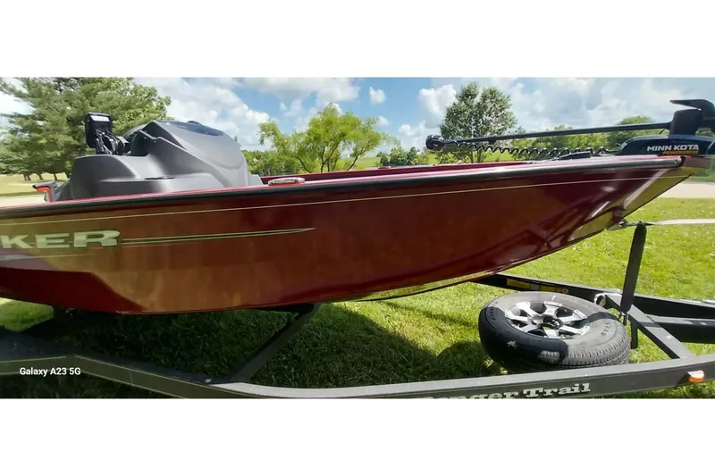 Slide: The Image of 2025 Tracker Super Guide V-16 SC boat on trailer, parked on grass under blue sky. - 6