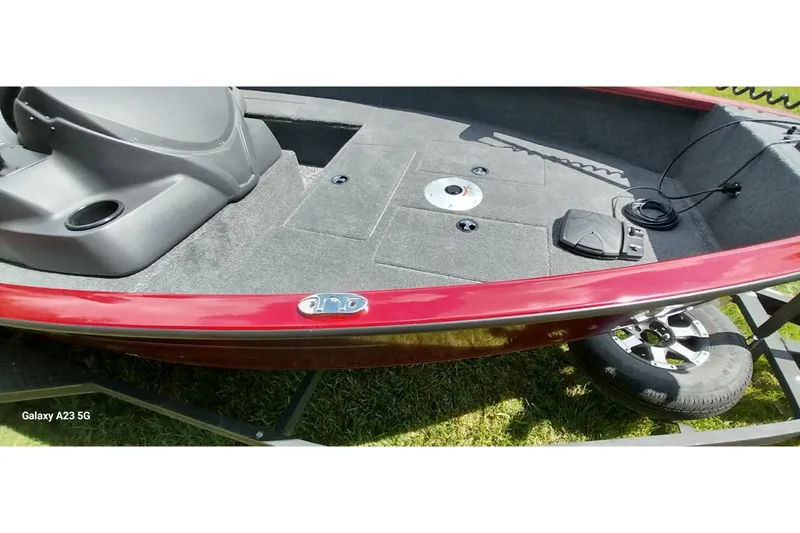 Slide: The Image of 2025 Tracker Super Guide V-16 SC boat interior with red trim and carpeted deck. - 7