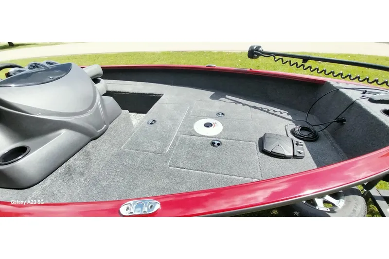 Slide: The Image of 2025 Tracker Super Guide V-16 SC boat interior with red trim and fishing equipment. - 8