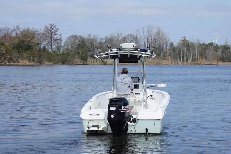 Slide: The Image of 2008 Seapro 206CC boat with Suzuki engine on calm water, surrounded by trees. - 12