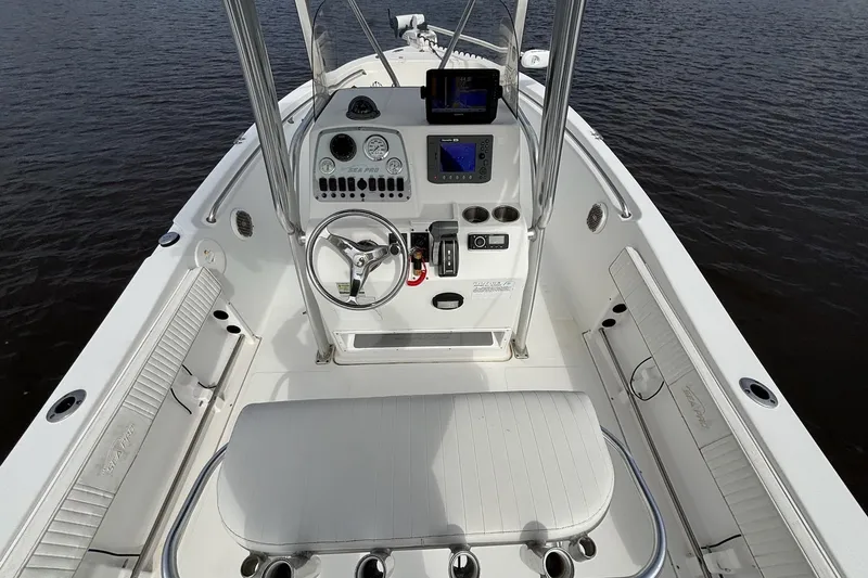 Slide: The Image of 2008 Seapro 206CC boat interior with steering console and seating, on calm water. - 8