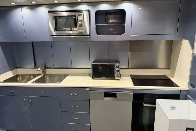 Slide: The Image of Modern kitchen in a 2005 Mangusta 92 yacht with appliances and sleek cabinetry. - 17