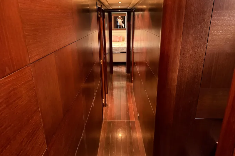 Slide: The Image of Narrow wooden hallway inside a 2005 Mangusta 92 yacht, leading to a bedroom. - 18