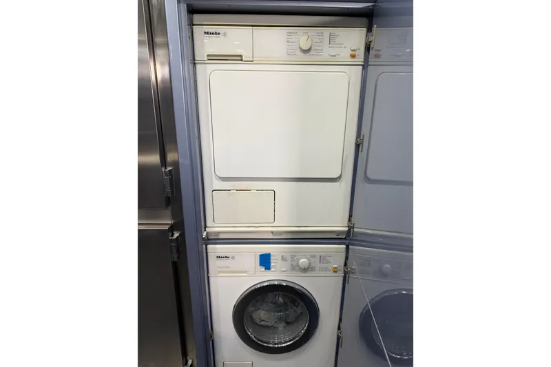 Slide: The Image of Stacked Miele washer and dryer inside a 2005 Mangusta 92 yacht. - 20