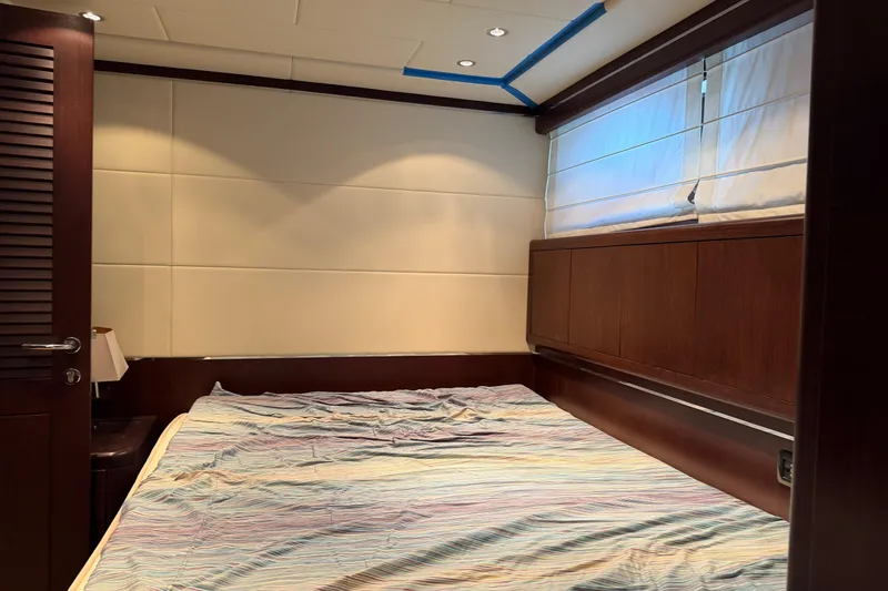 Slide: The Image of Luxurious bedroom interior of 2005 Mangusta 92 yacht with wooden accents and cozy bedding. - 25