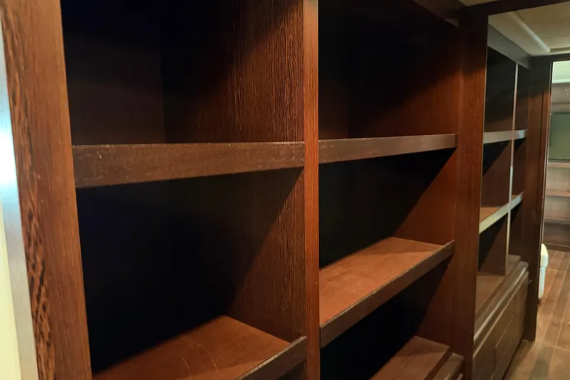 Slide: The Image of Empty wooden shelves inside a 2005 Mangusta 92 yacht interior. - 36