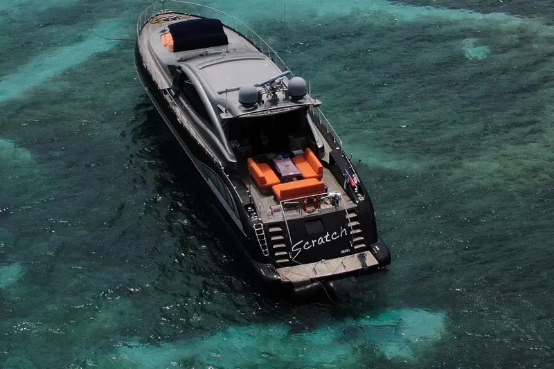 Slide: The Image of Luxurious 2005 Mangusta 92 yacht named "Scratch" on clear turquoise waters. - 4
