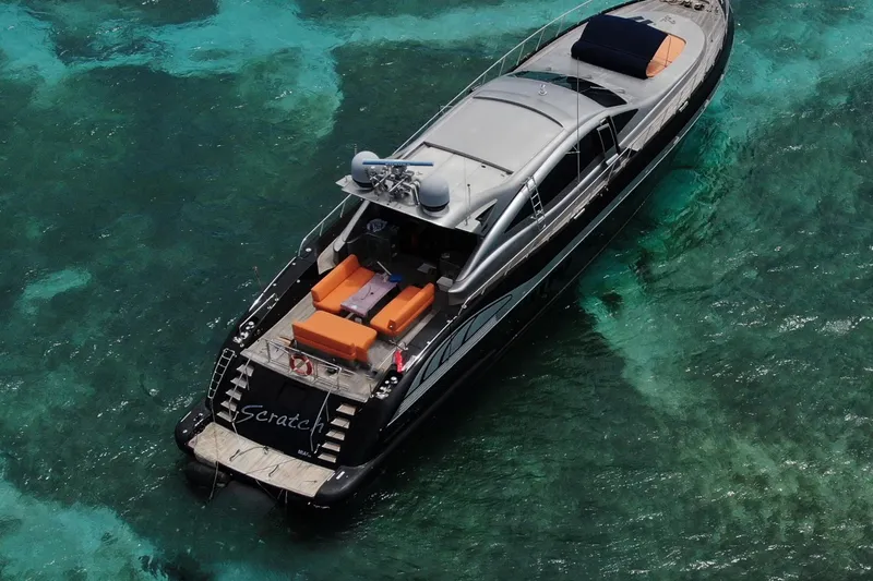 Slide: The Image of Luxury 2005 Mangusta 92 yacht on clear turquoise waters, featuring sleek design and spacious deck. - 5