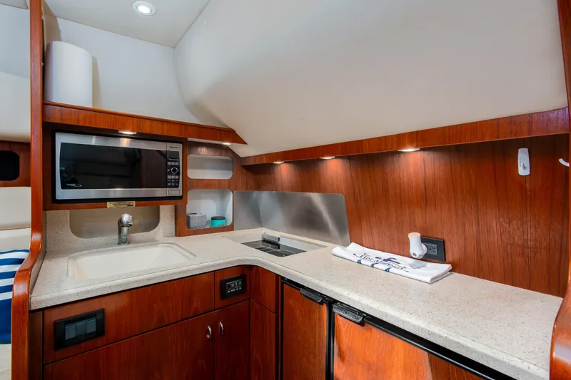 Slide: The Image of 2007 Tiara Yachts 3800 Open galley with wood cabinetry and modern appliances. - 28
