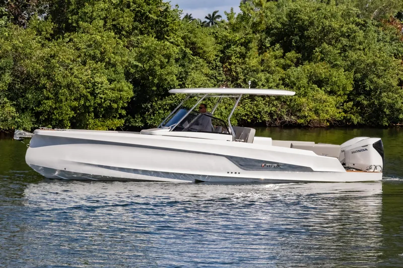 The Image of 2025 STERK 31 boat cruising on a calm river with lush greenery. - 0