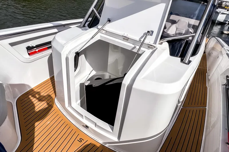 Slide: The Image of 2025 STERK 31 boat with open storage compartment, featuring sleek design and wooden deck. - 14