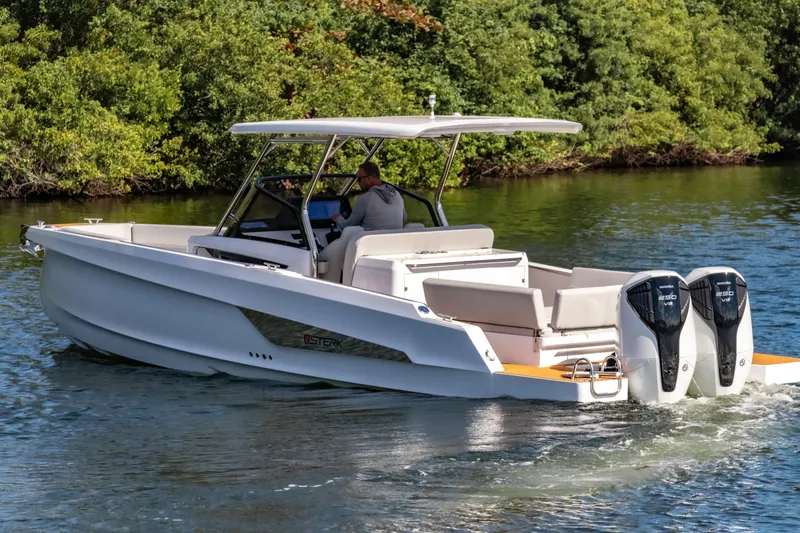 Slide: The Image of 2025 STERK 31 boat cruising on a serene waterway with lush greenery. - 5