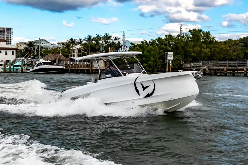 Slide: The Image of 2025 STERK 31 boat cruising on water near a marina, under a partly cloudy sky. - 2