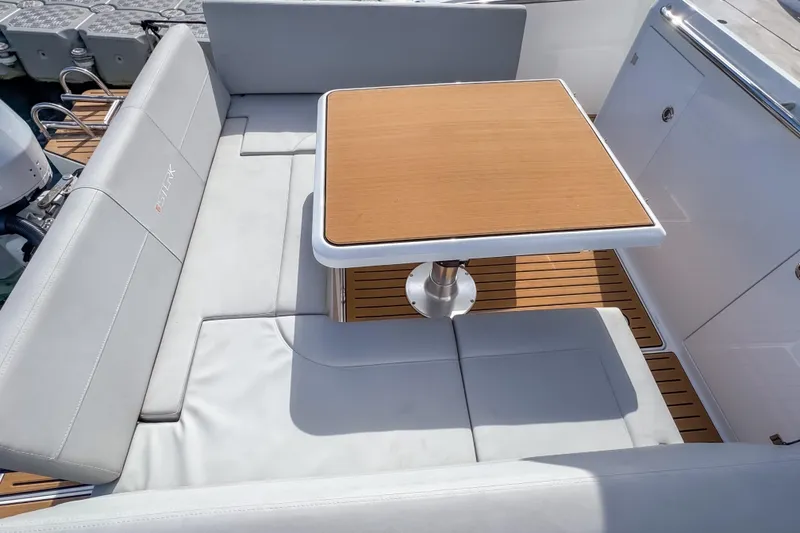 Slide: The Image of Luxurious seating area on 2025 STERK 31 boat with wooden table and cushioned seats. - 8
