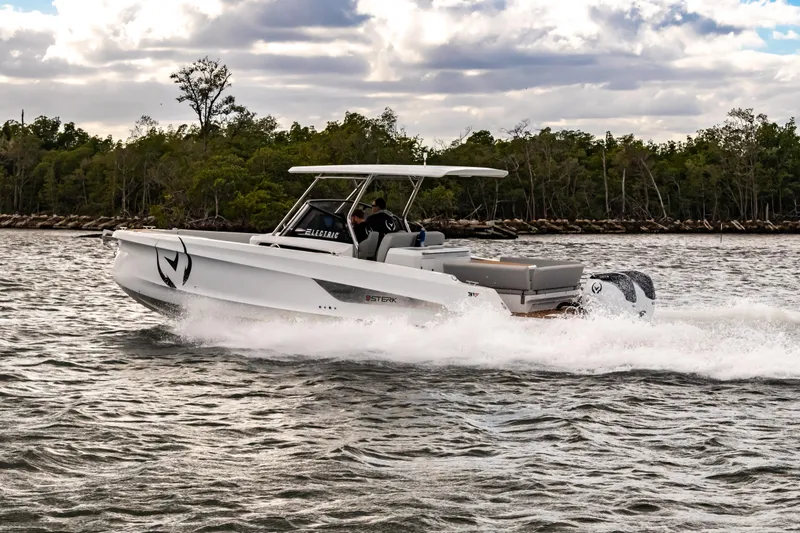 Slide: The Image of Electric STERK 31 boat cruising on water, 2025 model, with lush greenery in background. - 20