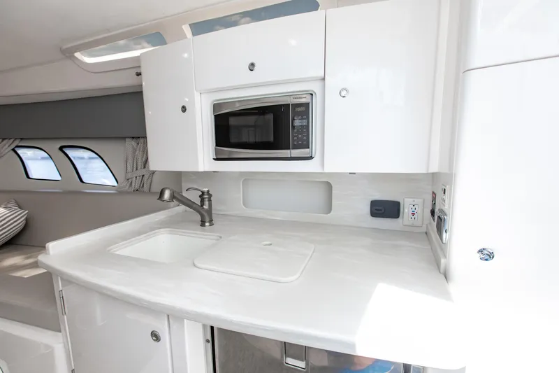 Slide: The Image of 2016 Intrepid 400 Cuddy interior with modern kitchenette, featuring sink and microwave. - 11