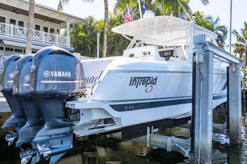 Slide: The Image of 2016 Intrepid 400 Cuddy boat with Yamaha engines docked near a waterfront home. - 137