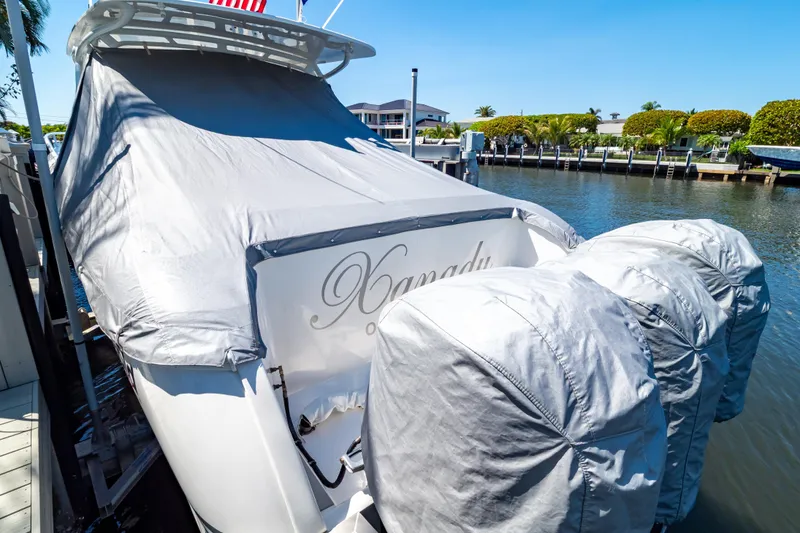 Slide: The Image of Covered 2016 Intrepid 400 Cuddy boat docked by waterfront homes. - 140