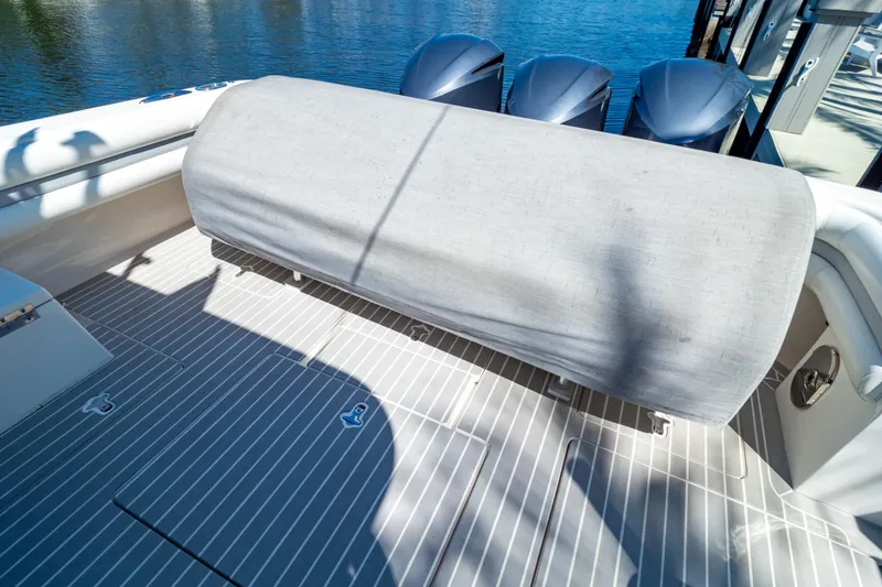 Slide: The Image of 2016 Intrepid 400 Cuddy boat deck with covered seating and triple outboard engines. - 142