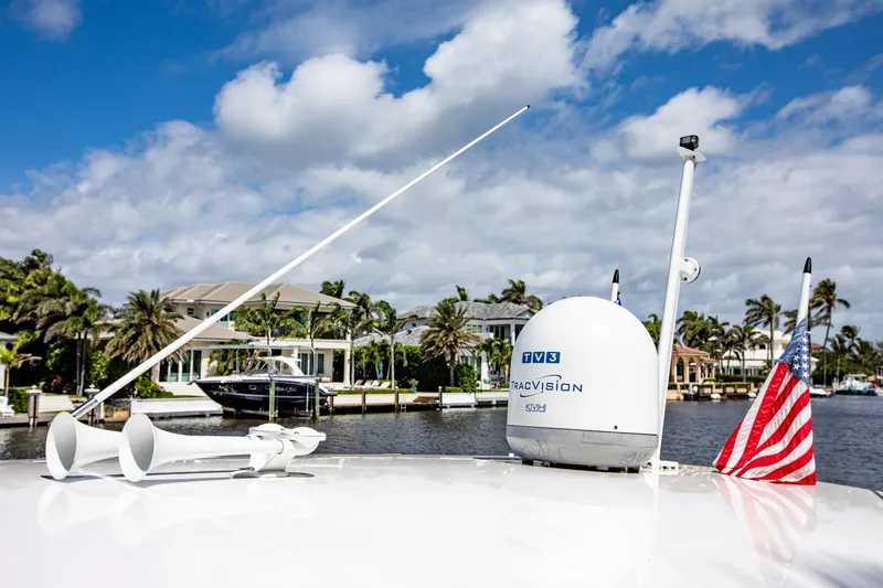 Slide: The Image of 2016 Intrepid 400 Cuddy boat with TracVision satellite, American flag, and waterfront homes. - 15