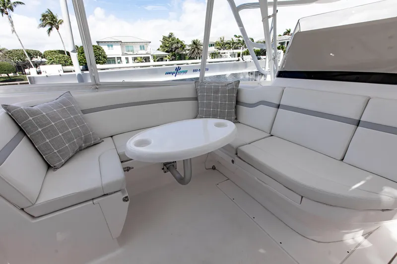 Slide: The Image of 2016 Intrepid 400 Cuddy boat interior with cushioned seating and round table. - 16