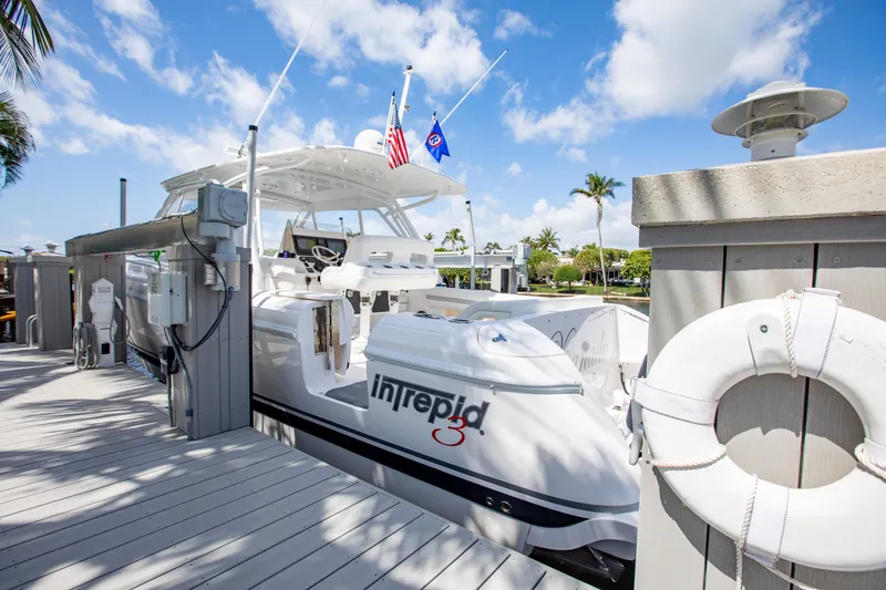 Slide: The Image of 2016 Intrepid 400 Cuddy docked, featuring sleek design and vibrant flags under a blue sky. - 23
