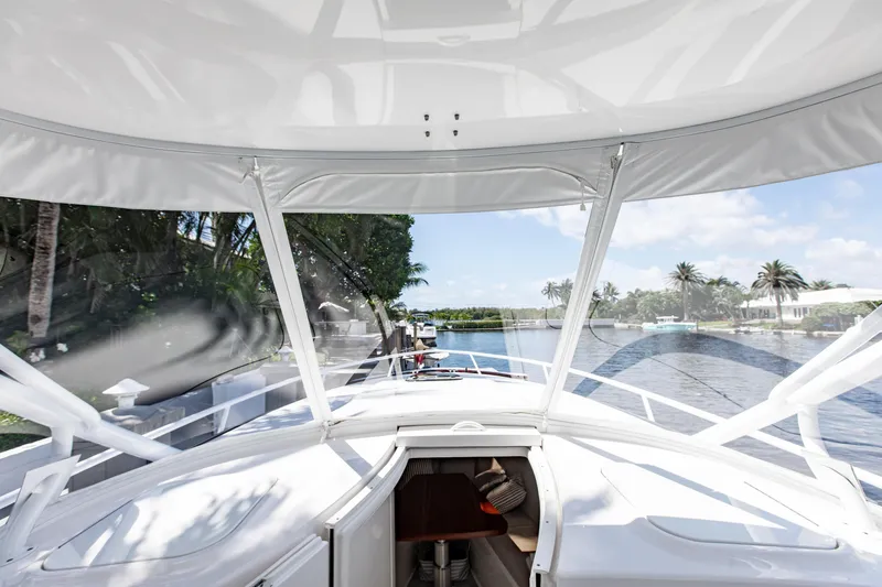 Slide: The Image of 2016 Intrepid 400 Cuddy boat interior with waterfront view and palm trees. - 32