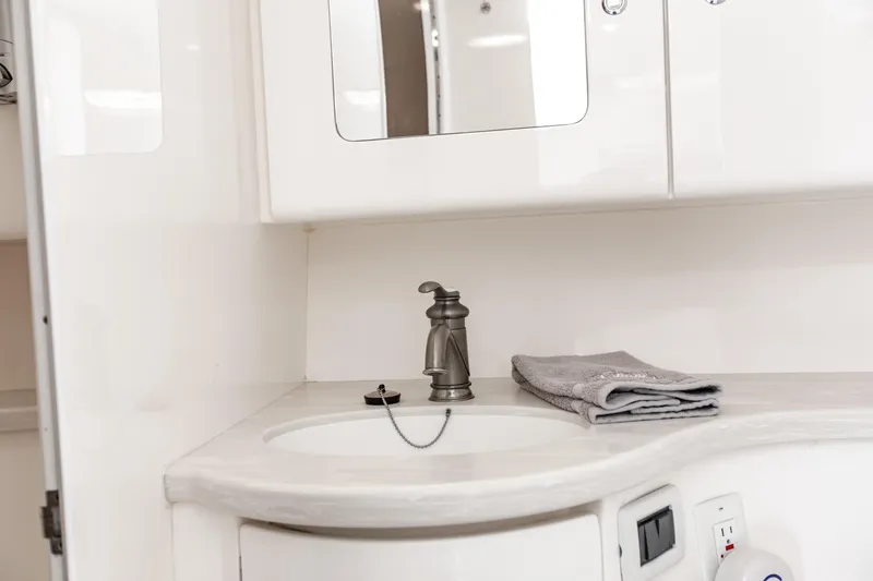 Slide: The Image of Intrepid 400 Cuddy 2016 boat bathroom with sink, faucet, and folded towels. - 33