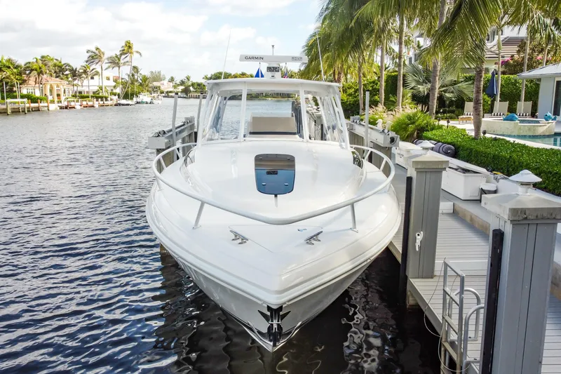 Slide: The Image of 2016 Intrepid 400 Cuddy boat docked by palm trees and waterfront homes. - 41