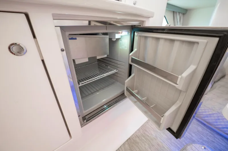 Slide: The Image of Open refrigerator inside 2016 Intrepid 400 Cuddy boat, showcasing interior storage space. - 61