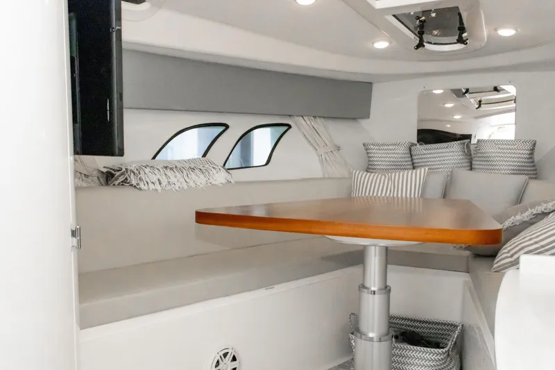 Slide: The Image of Interior of 2016 Intrepid 400 Cuddy with cozy seating and wooden table. - 69