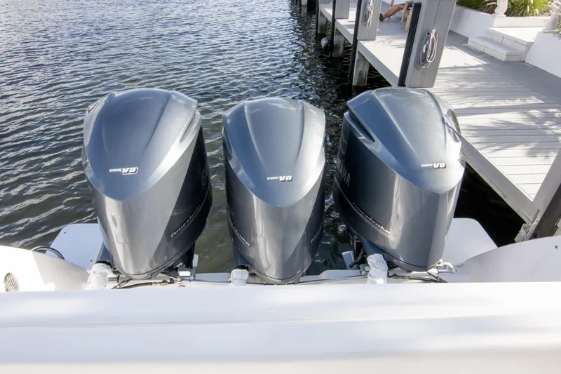 Slide: The Image of Triple Yamaha V8 engines on a 2016 Intrepid 400 Cuddy boat docked by the water. - 76