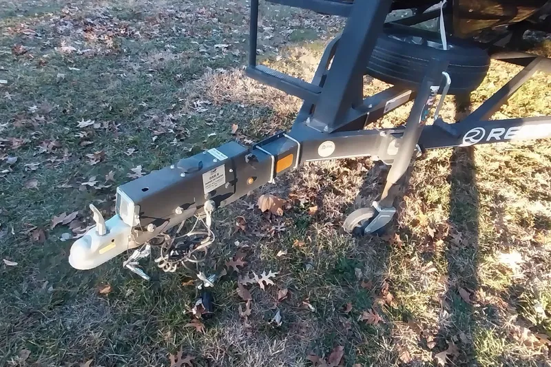 Slide: The Image of Trailer hitch of a 2021 Regency 230 LE3 Sport on grassy ground. - 2