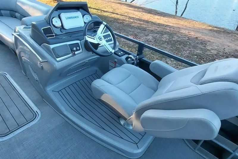 Slide: The Image of 2021 Regency 230 LE3 Sport boat interior with steering wheel and comfortable seating. - 20